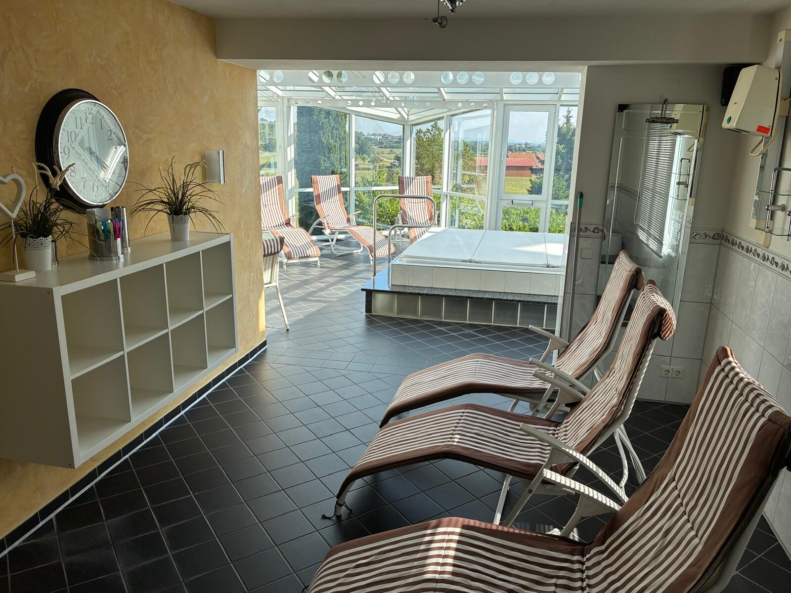 Ruhebereich mit Liegen und Blick zum Whirlpool