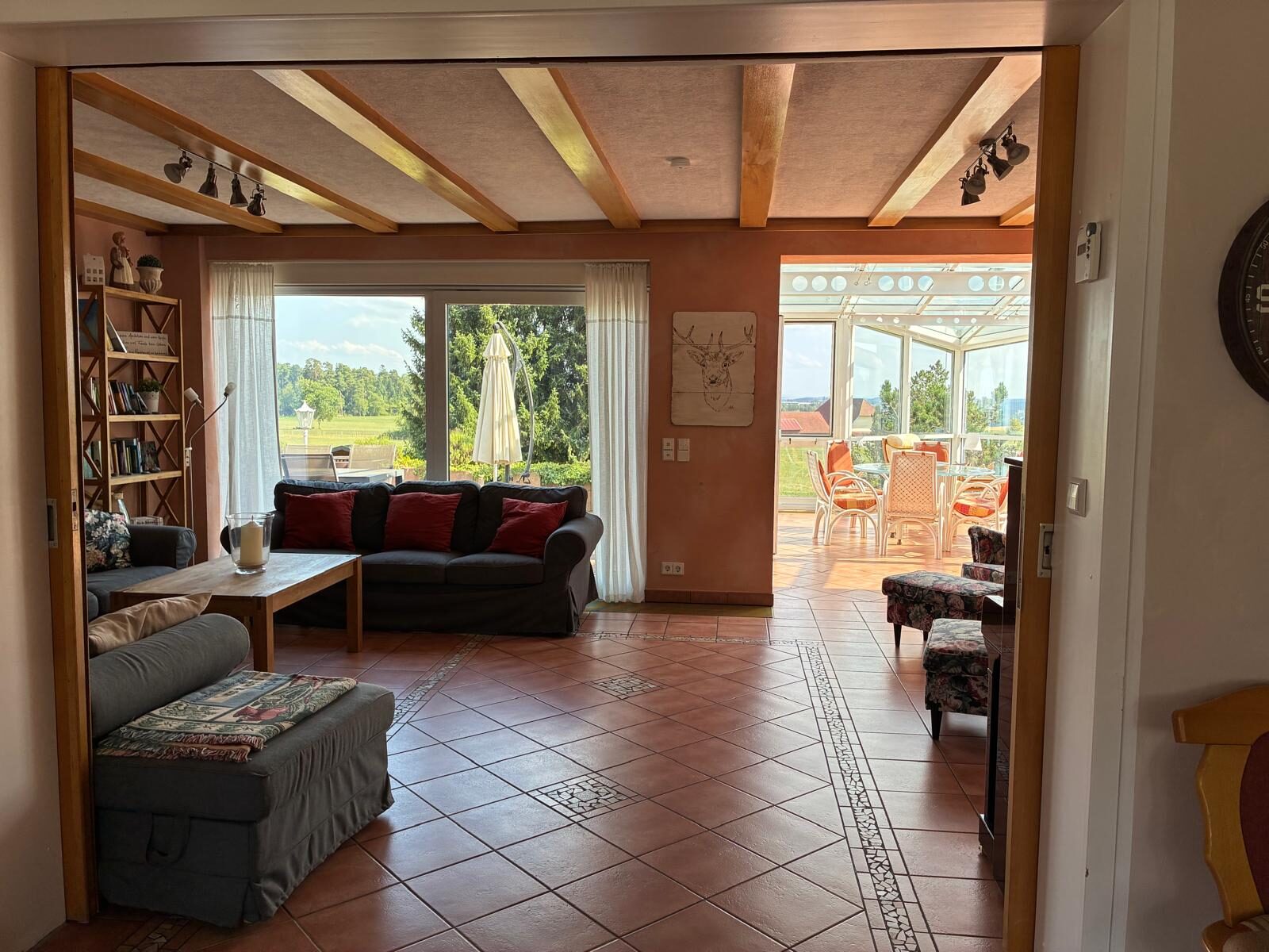 Wohnzimmer mit Sofaecke und Durchblick in den Wintergarten