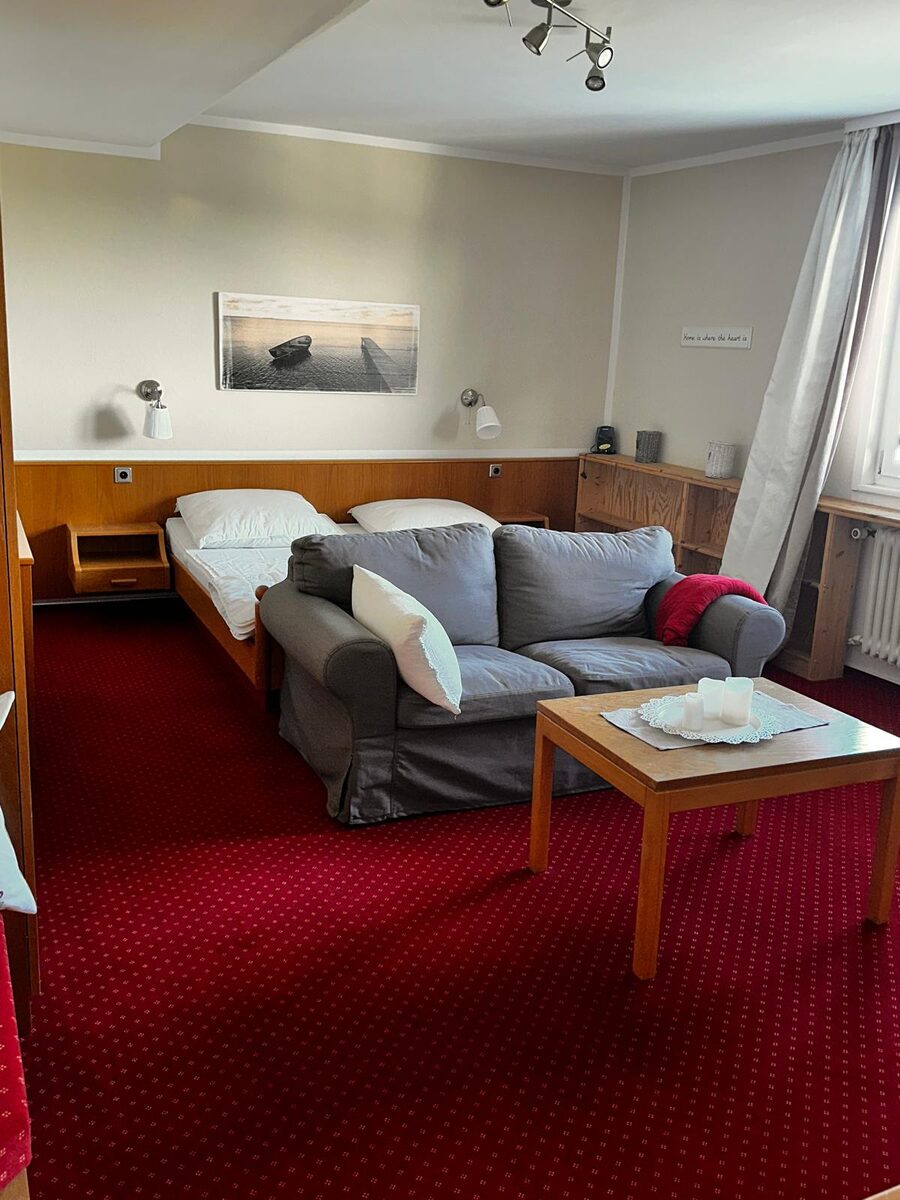 Helles Zimmer mit Bett und Sofaecke