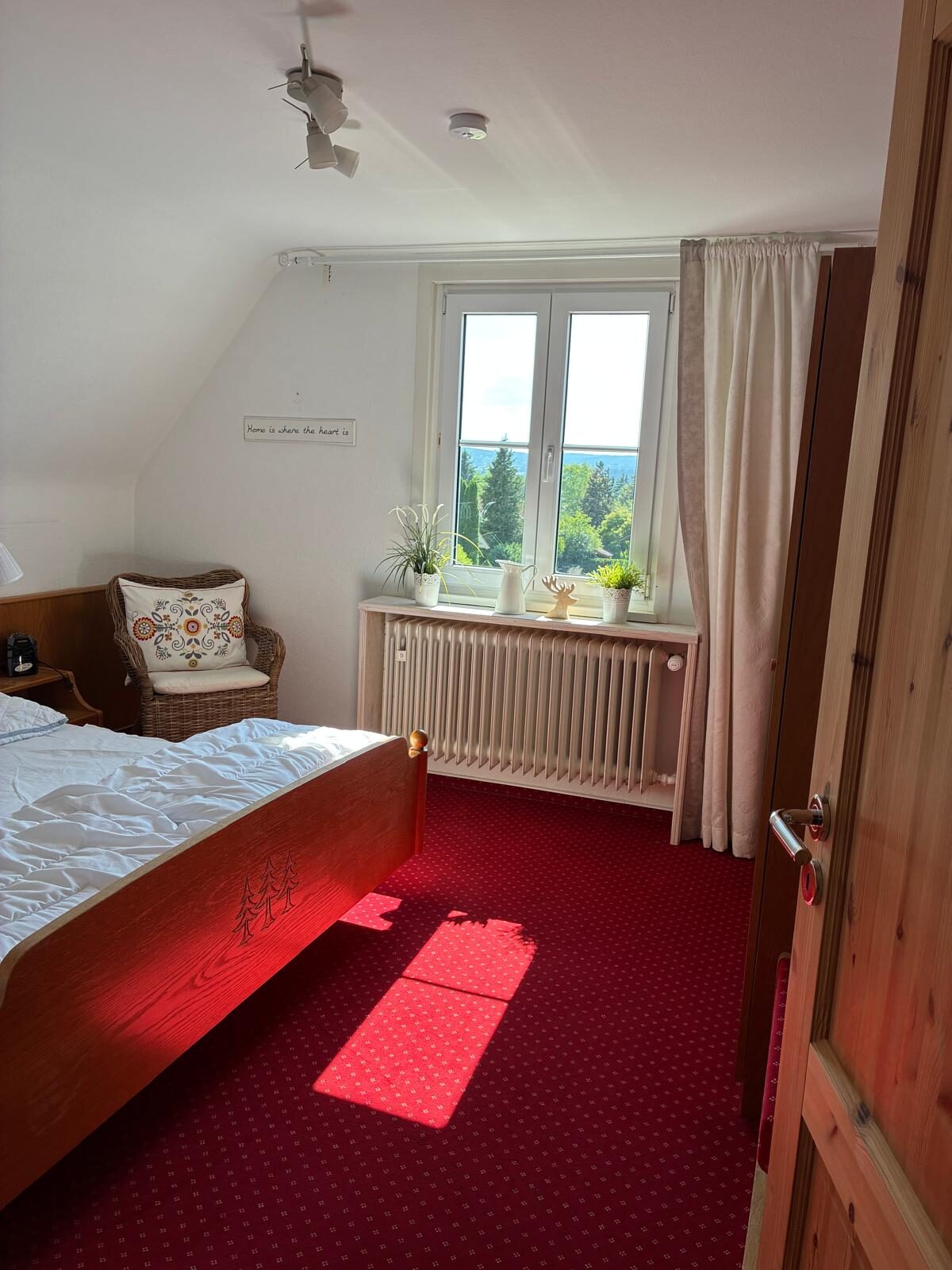 Zimmer mit Bett, Fenster und Blick ins Grüne