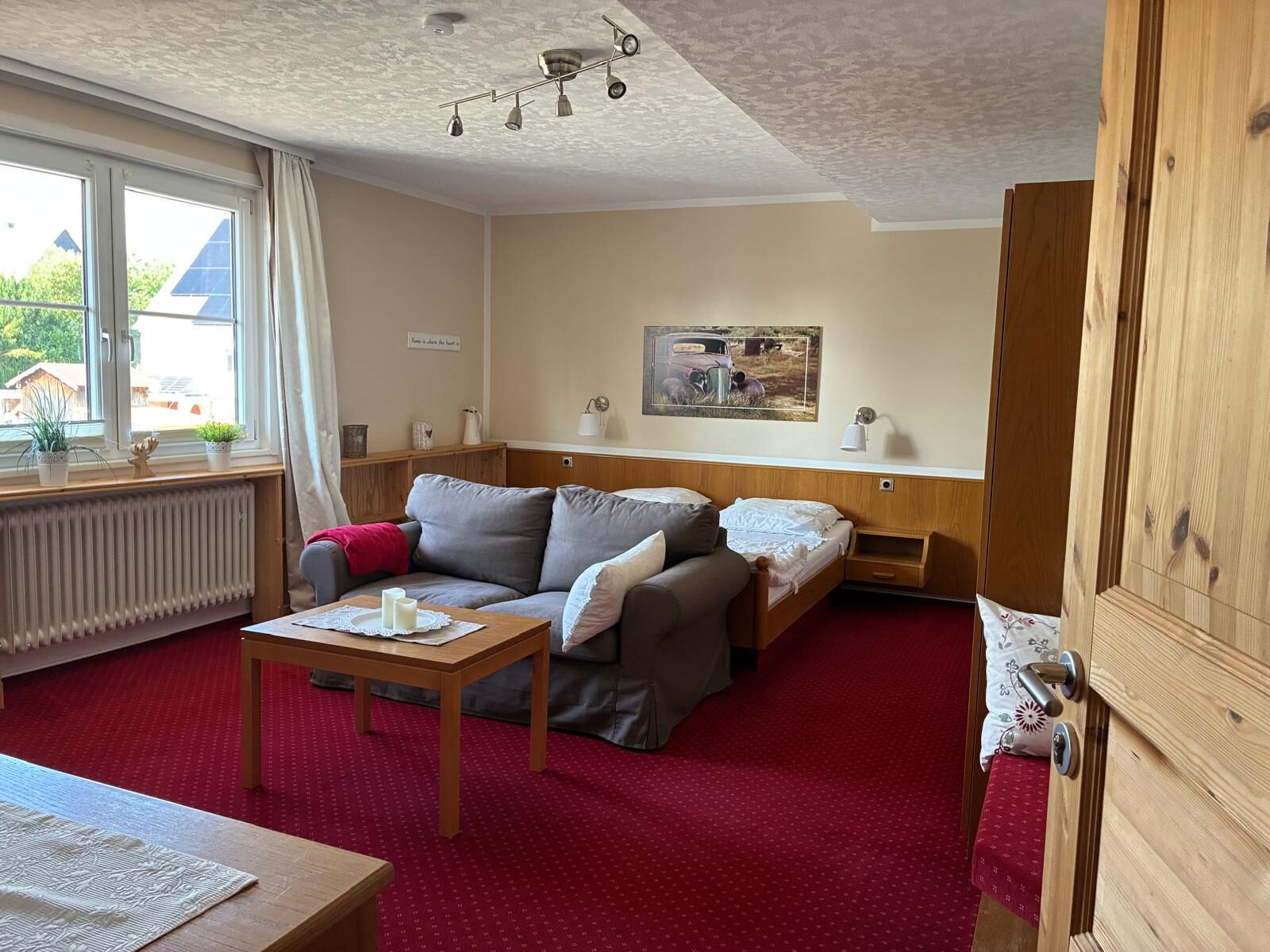 Helles Zimmer mit Sofaecke, Bett und Couchtisch